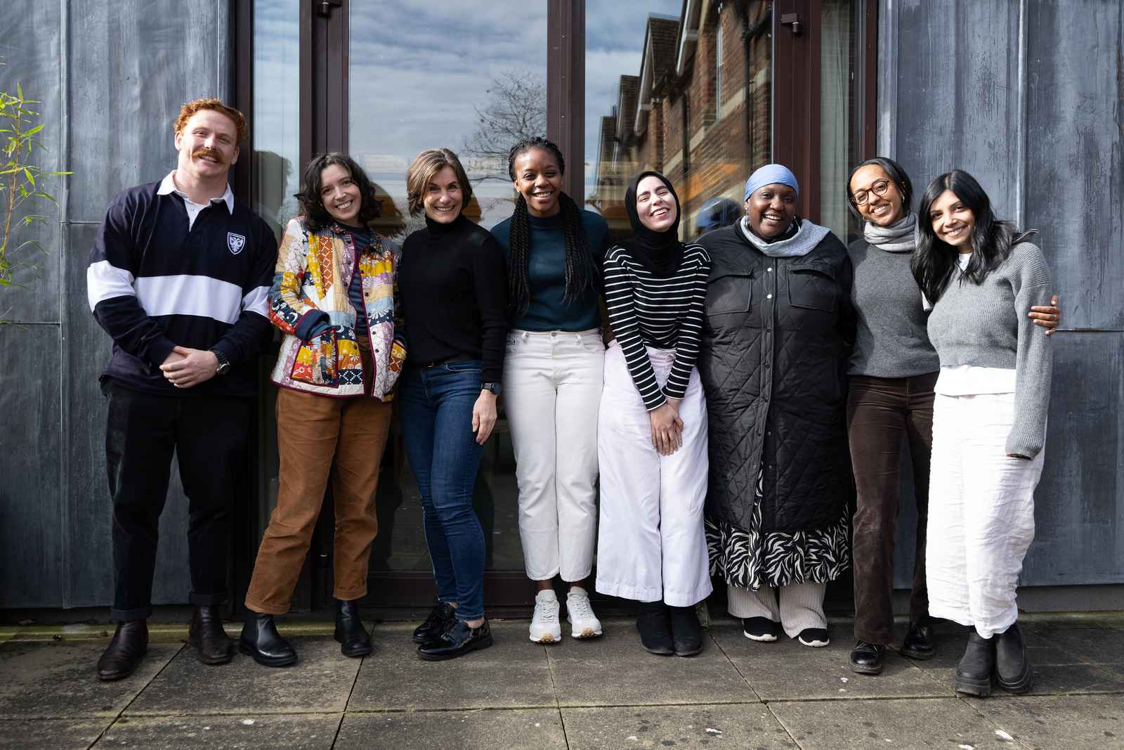 Group of seven international students standing outside.
