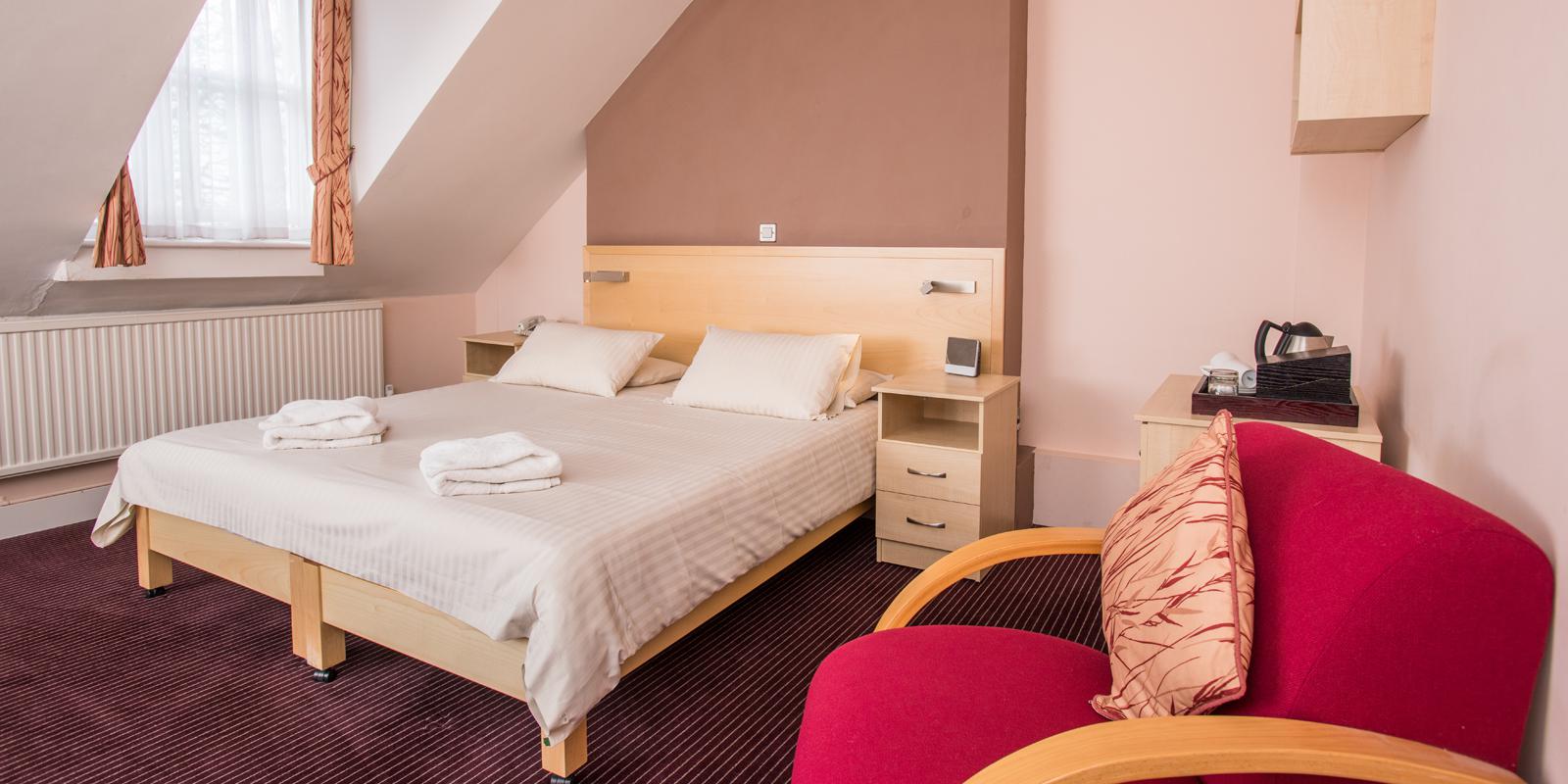 Rewley House bedroom with a double bed, tea and coffee making facilities and comfortable armchair