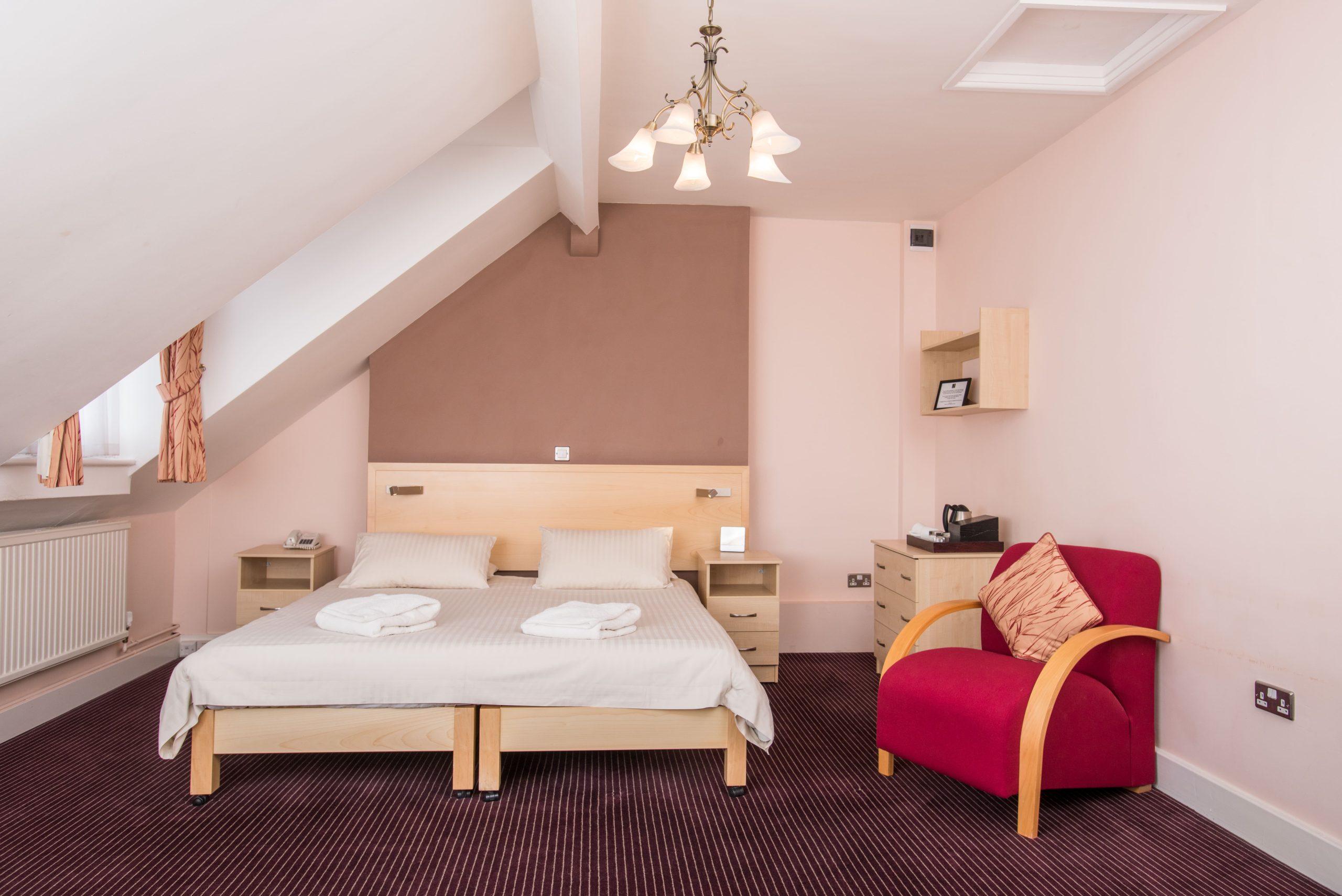 Rewley House bedroom with a double bed, tea and coffee making facilities and comfortable armchair