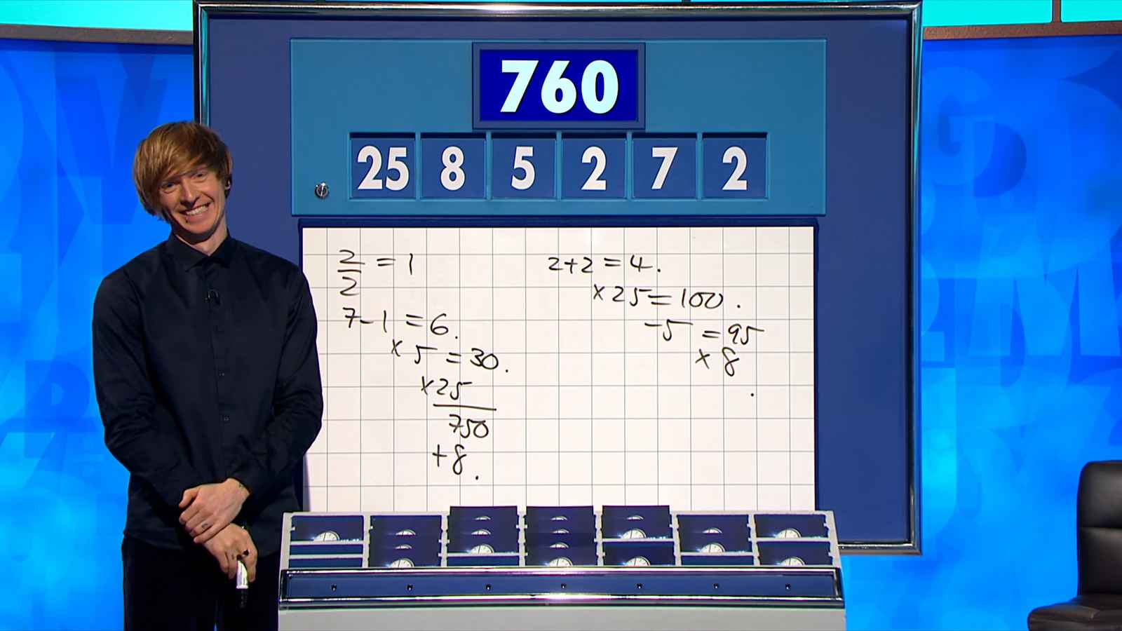 Dr Tom Crawford next to a whiteboard with an equation on the TV show, Countdown.