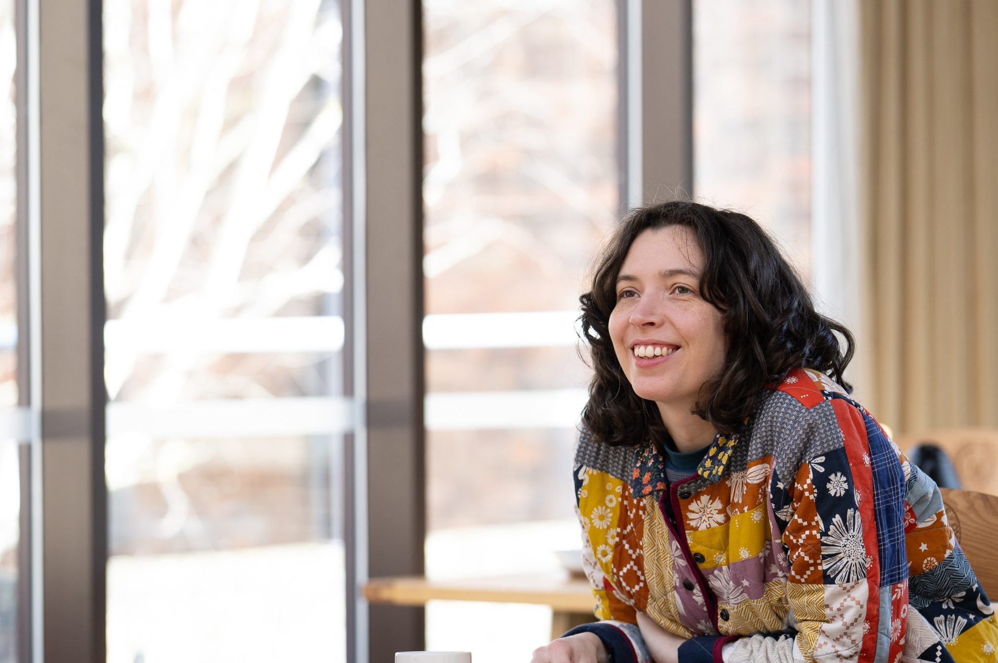 Woman in classroom smiling and chatting.