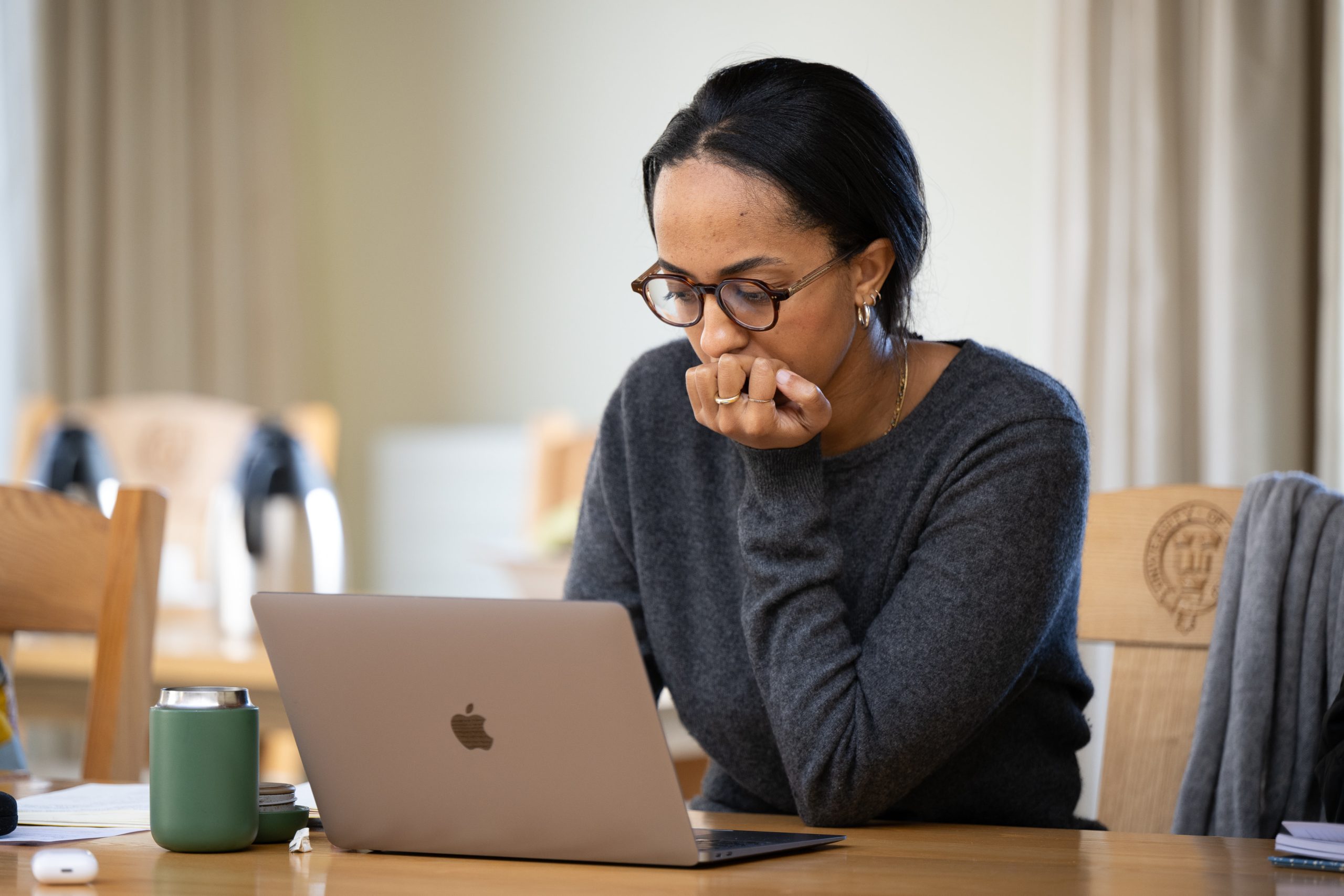 Woman sat in classroom looking at laptop.