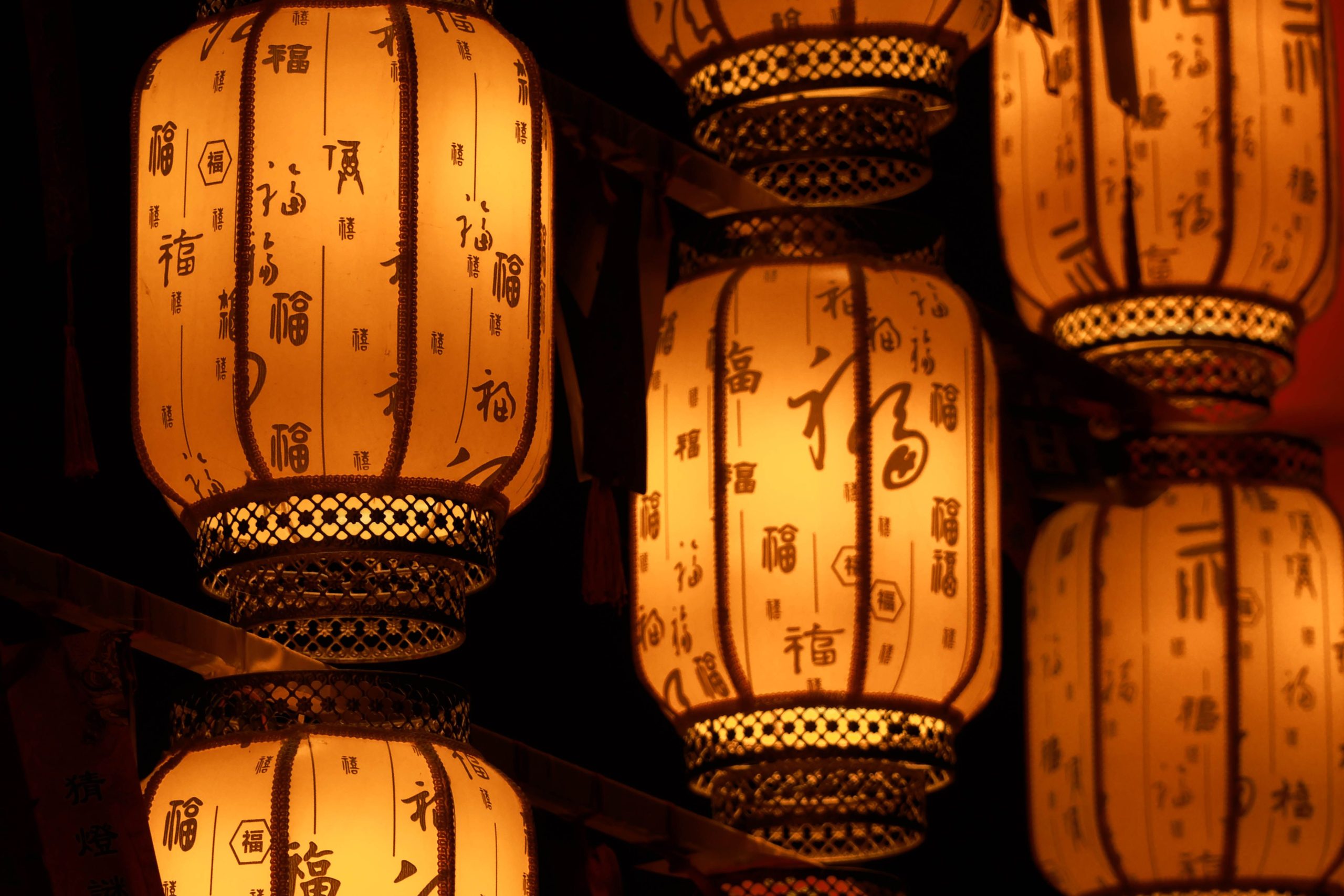 Chinese lanterns with calligraphy are lit up.