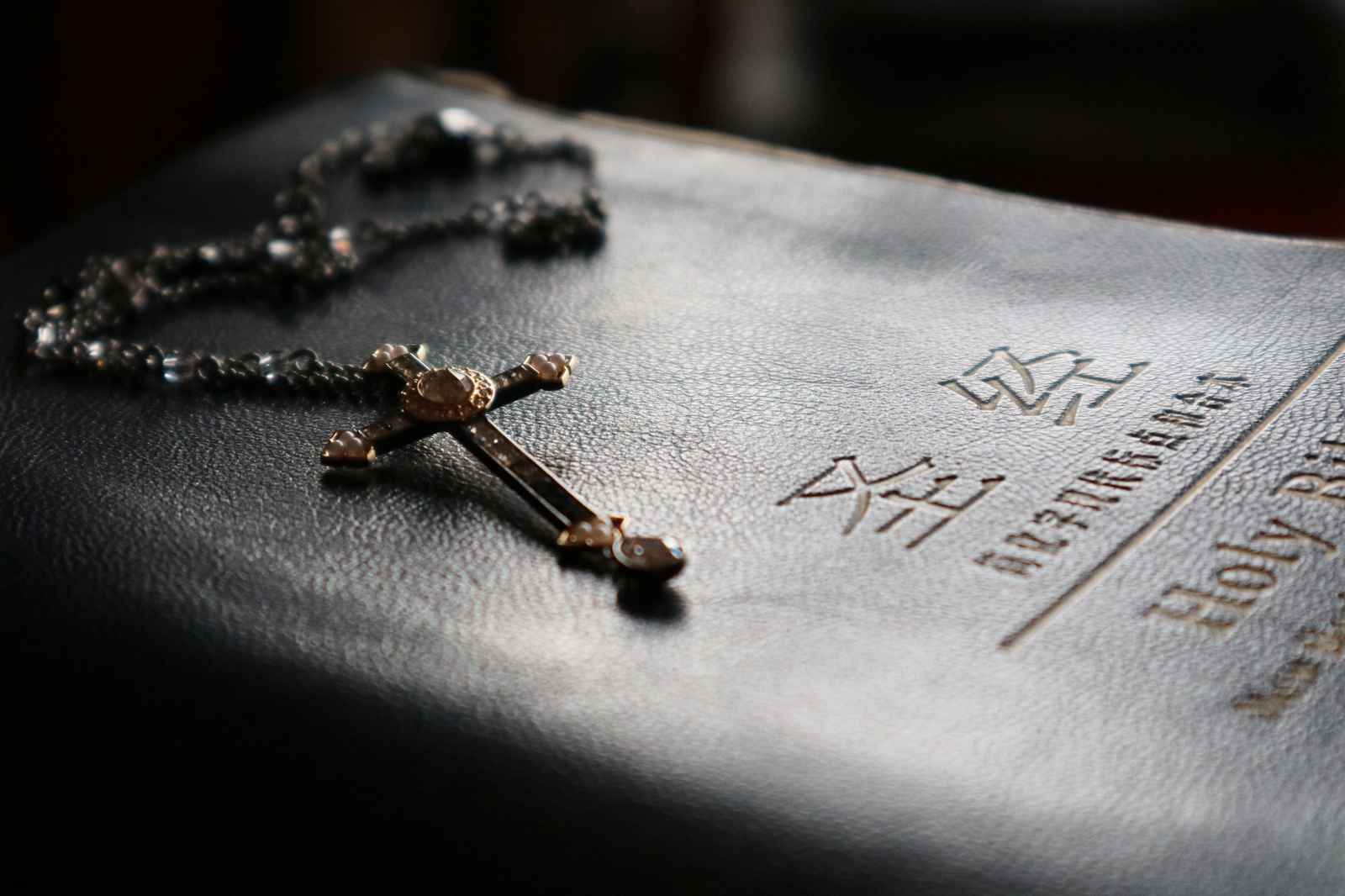 Selective focus photography of rosary, bible in Chinese.